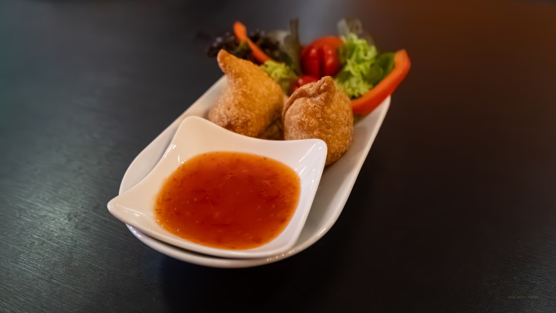 Vorspeise mit Chilisauce auf dunklem Tisch